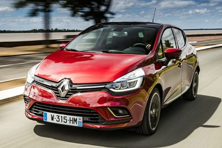 Berline rouge Renault Clio roulant sur route lors d un essai de voiture d occasion