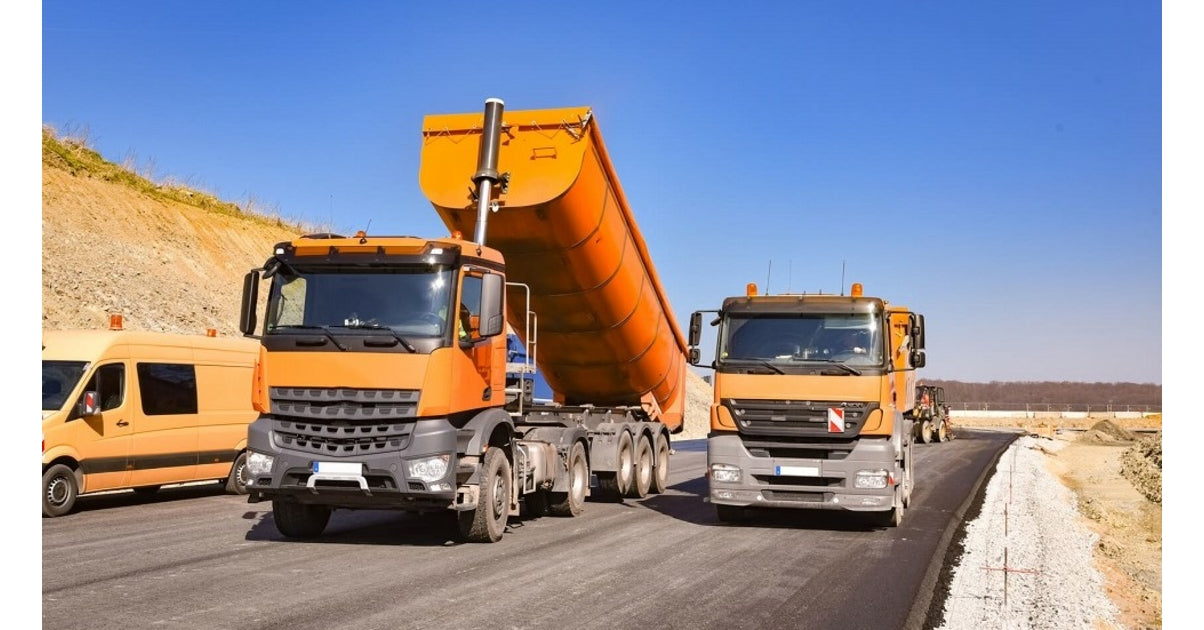 Camions de chantier orange sur une route en travaux pour diagnostic poids lourds