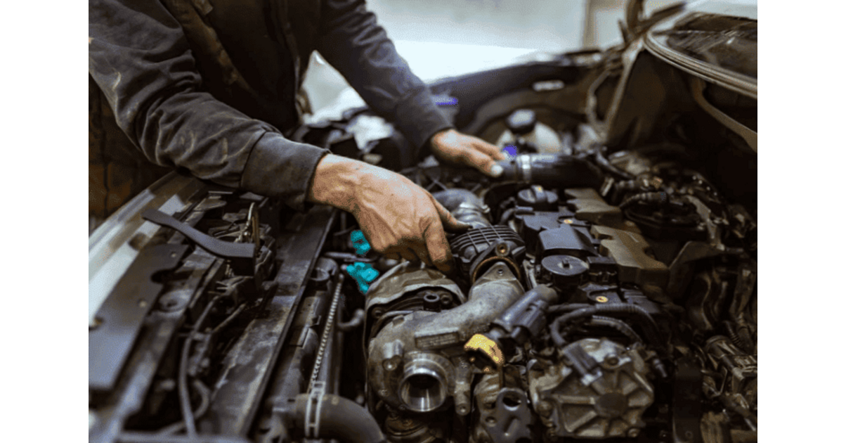 Mecanicien qui travaille sur le moteur lors du changement de turbo d une voiture