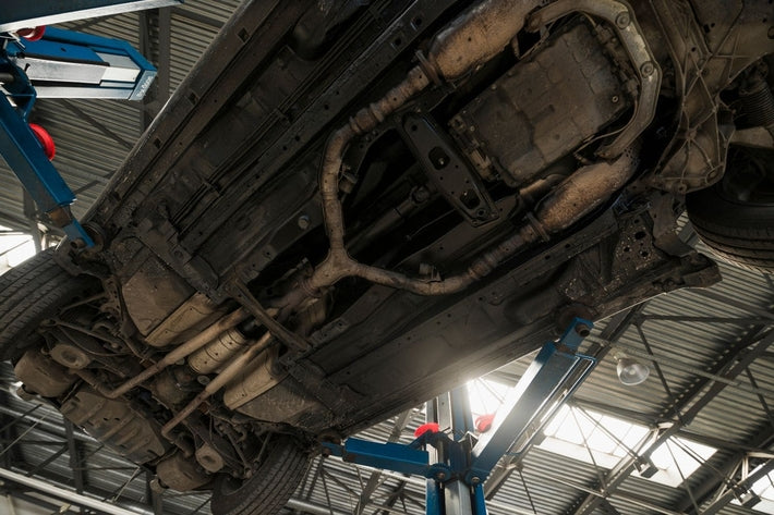 Vue de dessous du chassis de voiture sur un pont elevateur en atelier