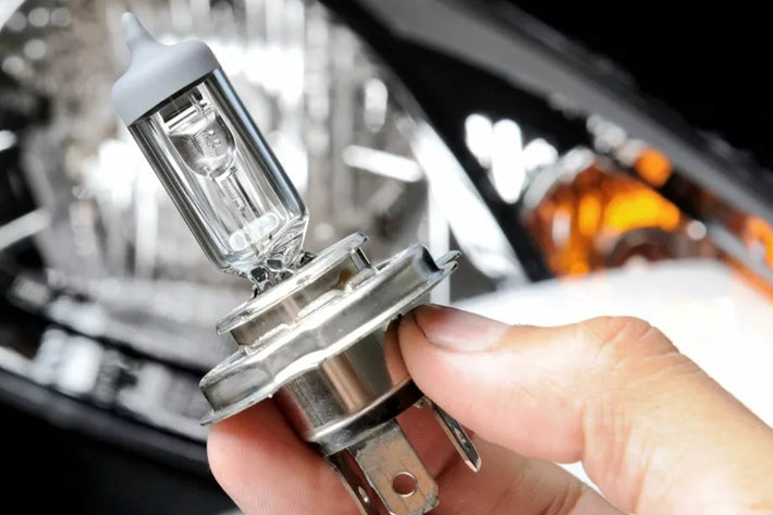 Main tenant une ampoule halogène H4 neuve pour le changement de phare de voiture