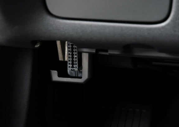 Gros plan sur l emplacement de la prise diagnostic OBD2 noire sous le tableau de bord d une voiture