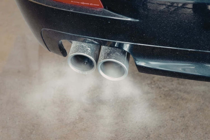 Échappement de voiture émettant de la fumée blanche indiquant un problème moteur