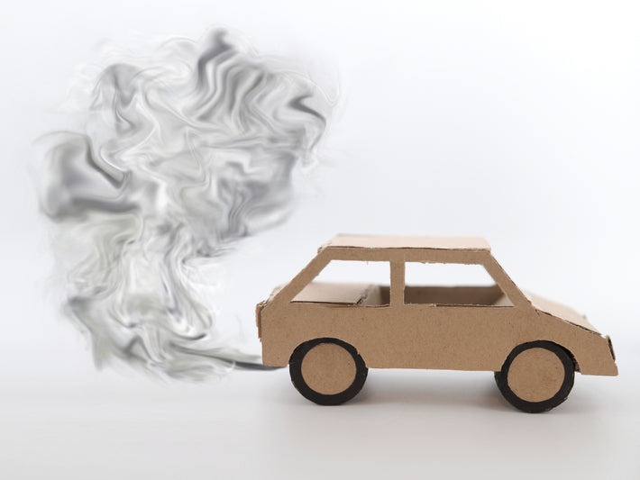 Voiture en carton rejetant de la fumee noire pour illustrer un probleme de pollution