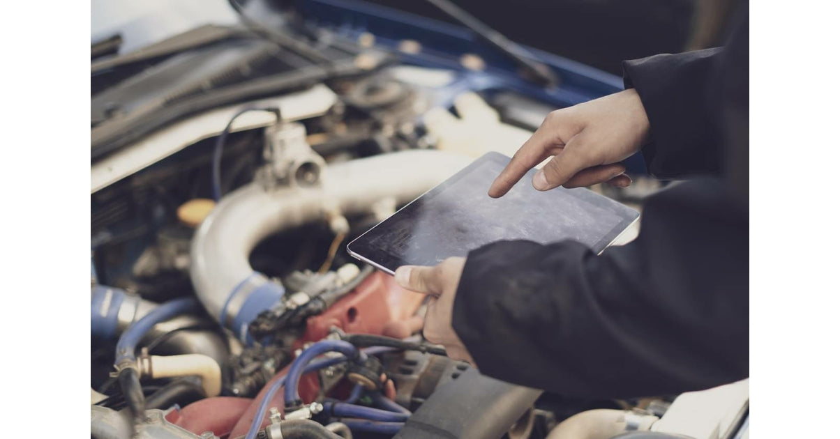 Mécanicien utilisant la tablette de diagnostic iCarsoft CR Max devant le moteur d'une voiture