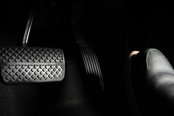 Gros plan sur les pedales d une voiture avec une chaussure pres de l accelerateur