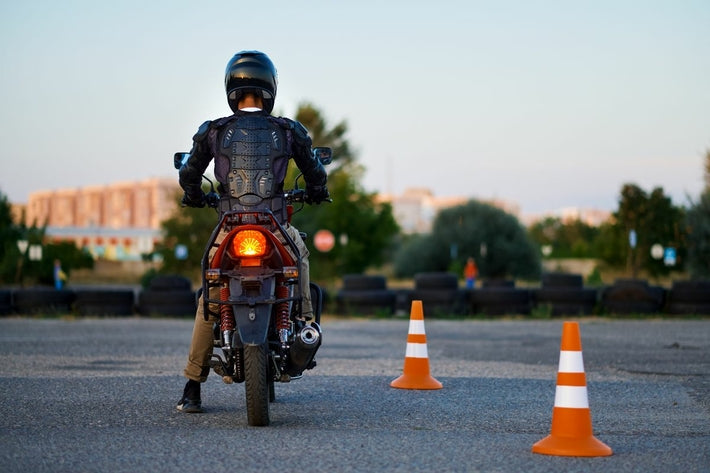 Motard de dos sur son deux-roues lors de l épreuve pratique du permis moto sur un plateau