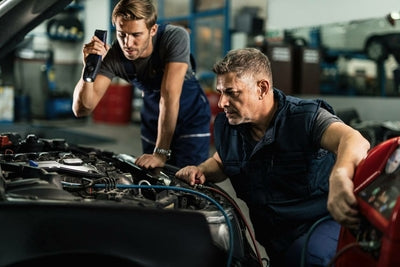 Deux mecaniciens inspectent le moteur d une voiture avec une valise de diagnostic auto