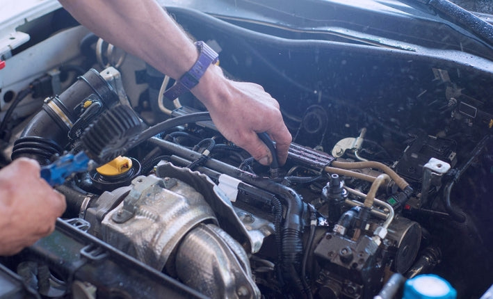 Mécanicien travaillant sur le moteur d une voiture pour estimer le prix du changement de turbo