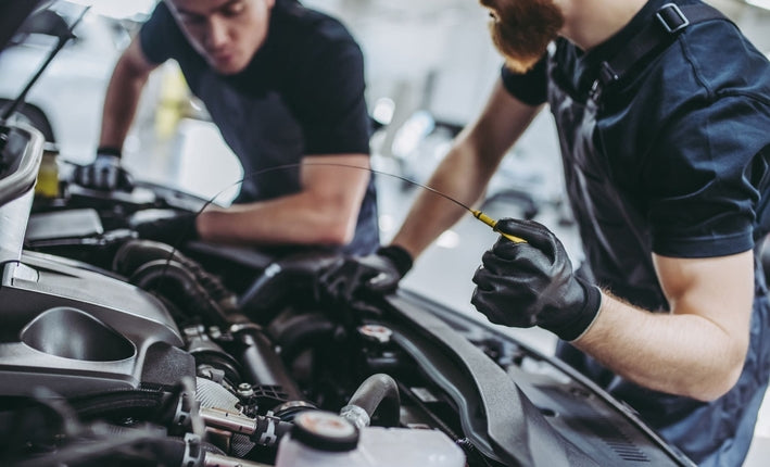 Deux mecaniciens verifient le niveau d huile moteur pour estimer le prix d un turbo de voiture