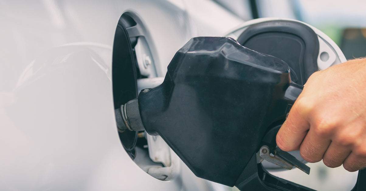 Une main insère un pistolet de carburant dans le réservoir d une voiture blanche pour faire le plein de bioéthanol E85