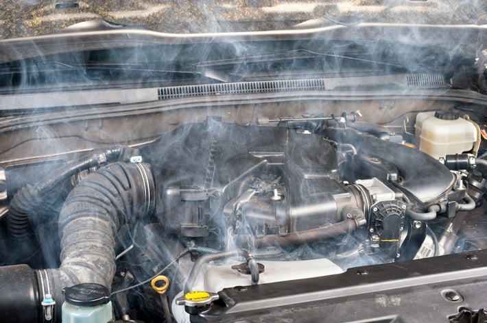 Surchauffe moteur avec de la fumee blanche s'echappant du capot ouvert d'une voiture