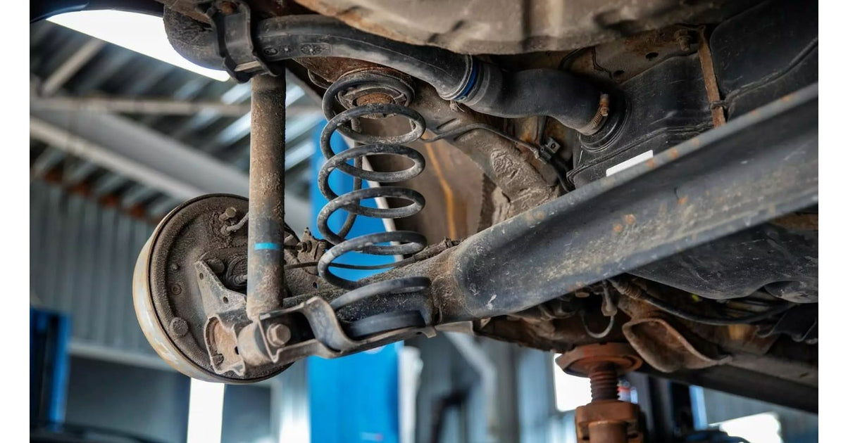 Vue sous un vehicule avec un ressort de suspension et un amortisseur de voiture uses
