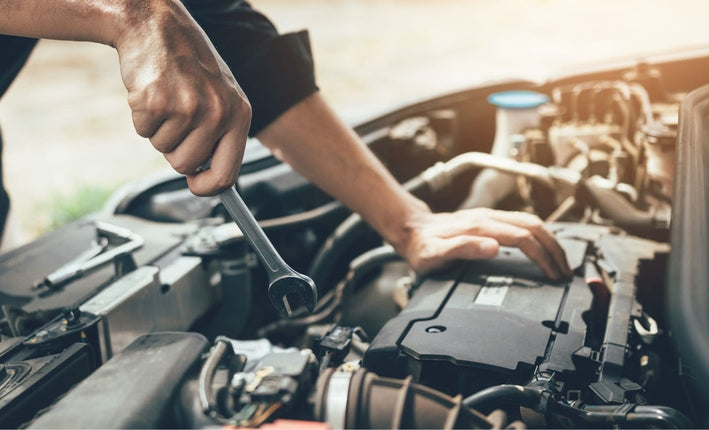 Mécanicien utilisant une clé plate sur le moteur d une voiture pour changer le turbo