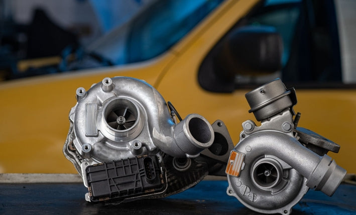 Deux turbocompresseurs de voiture neufs poses sur un etabli dans un garage