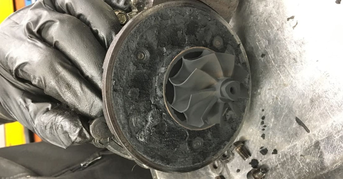 Démontage d'un turbo de voiture très encrassé par de la suie de calamine