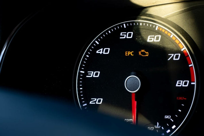 Gros plan sur un compteur de voiture avec les voyants EPC et moteur allumés