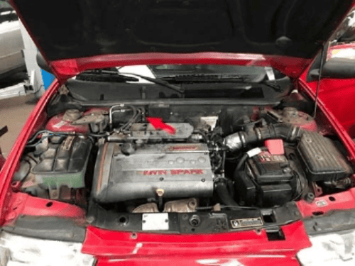 Vue du compartiment moteur d une Alfa Romeo 146 Twin Spark avec une fleche rouge indicative