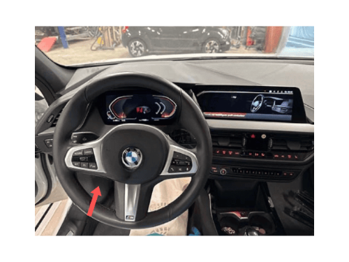 Volant sport M d une BMW Serie 1 F40 en cours de diagnostic avec une fleche rouge indicatrice