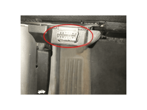 Prise de diagnostic OBD2 entouree en rouge sous le tableau de bord d une Chevrolet Impala