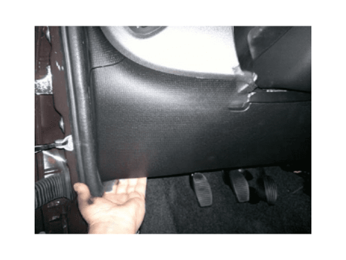 Main indiquant l'emplacement de la boite a fusibles sous le tableau de bord d'une Fiat Panda