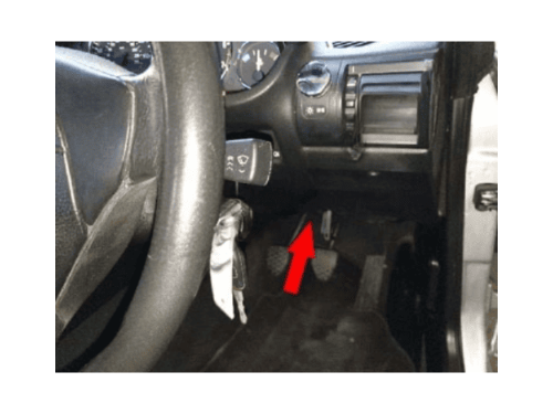 Fleche rouge indiquant l emplacement de la prise OBD sous le volant d une BMW Z3 conduite a droite