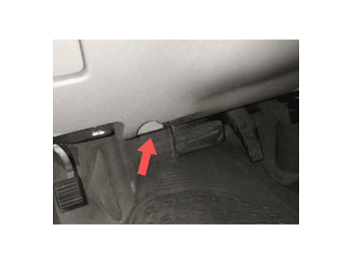 Une flèche rouge indique l'emplacement de la prise OBD2 sur une Chevrolet Malibu sous le tableau de bord