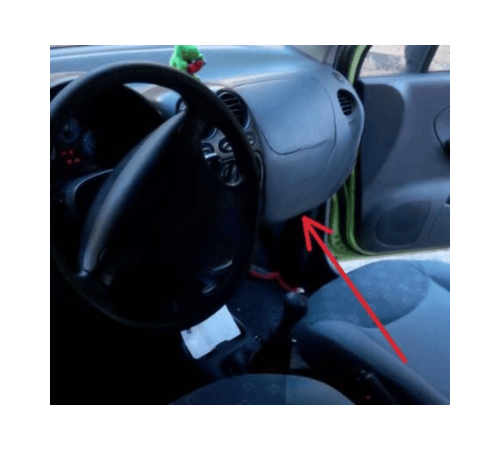 Une fleche rouge montre l emplacement de la prise OBD sur le tableau de bord d une Chevrolet Matiz