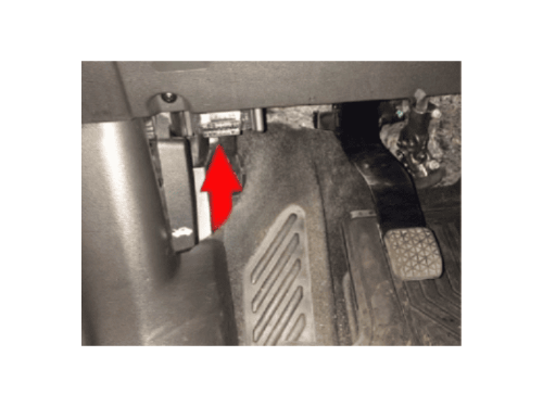 Flèche rouge montrant l'emplacement exact de la prise OBD sous le volant d'une Chevrolet Trax