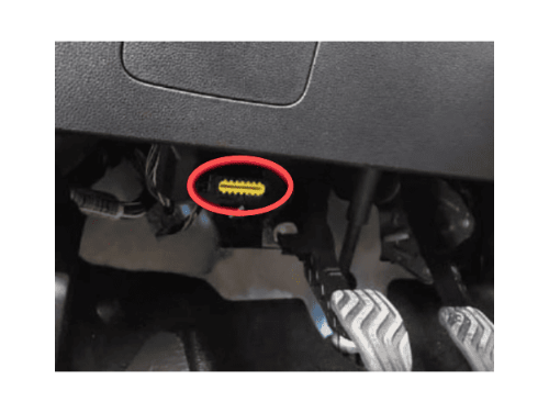 Prise diagnostic OBD jaune entouree de rouge sous le tableau de bord d une Dacia Logan 3