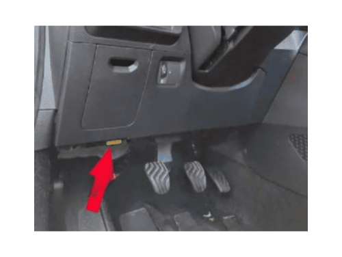 Une flèche rouge indique l'emplacement de la prise OBD2 sous le volant d'une Dacia Logan 3