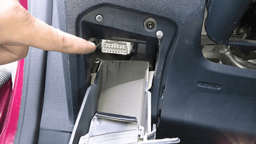 Doigt pointant vers l'emplacement de la prise de diagnostic OBD2 sur une Ford Fiesta