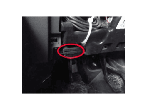 Emplacement de la prise de diagnostic OBD entouré en rouge sous le volant d'un Ford Transit