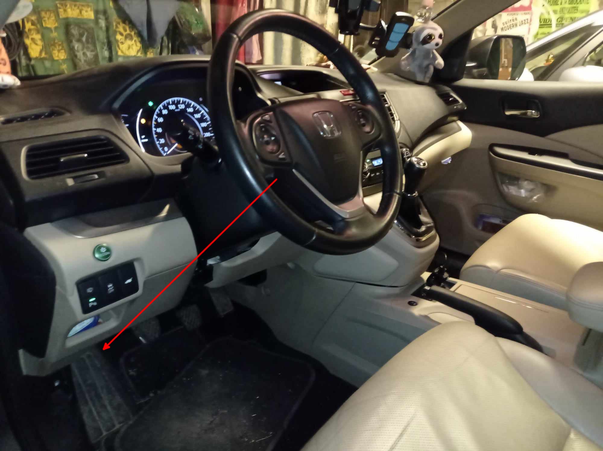 Fleche rouge indiquant l emplacement de la prise de diagnostic OBD sous le volant d une Honda CR-V