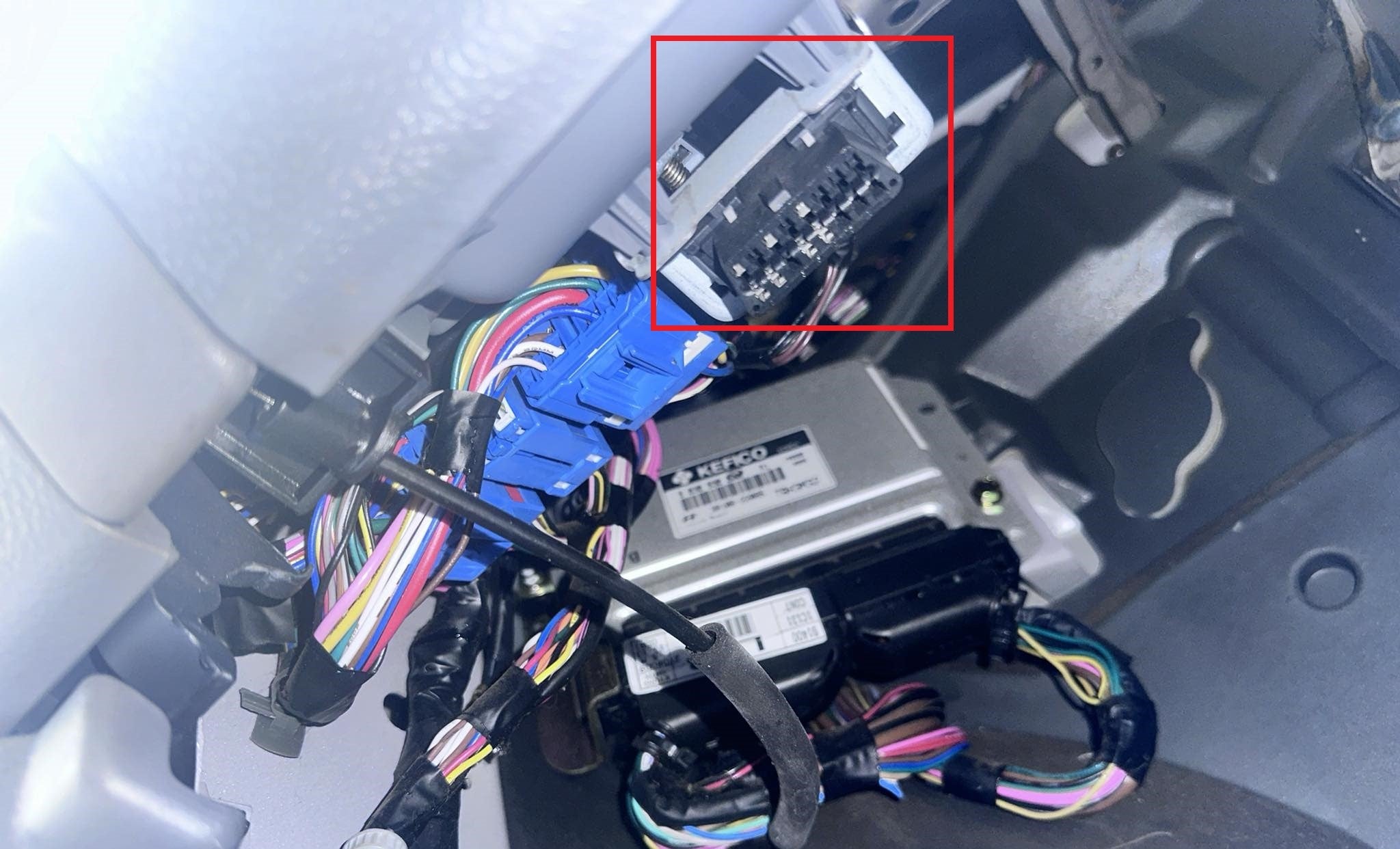 Localisation de la prise de diagnostic OBD2 sous le tableau de bord d'un véhicule