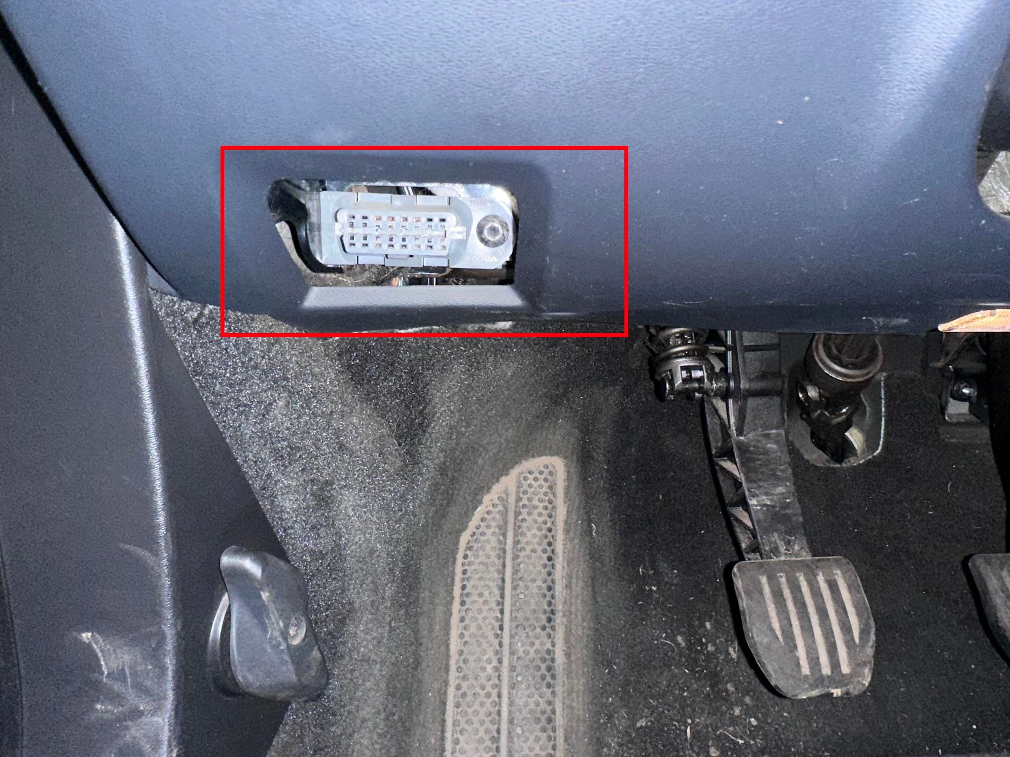 Vue de l'emplacement de la prise OBD de diagnostic sous le volant d'un véhicule