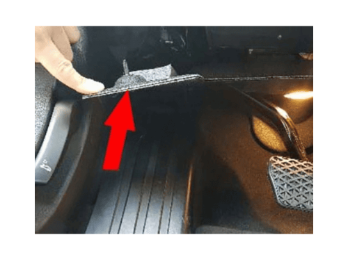 Localisation de la prise de diagnostic OBD derrière le repose-pied d'une BMW Série 7