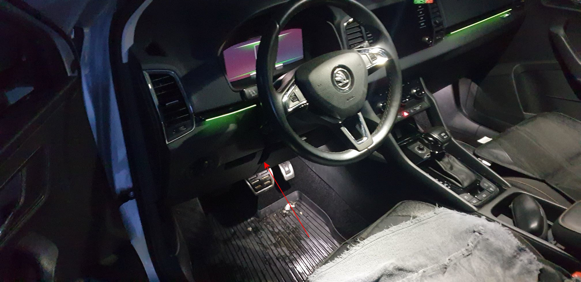 Une flèche rouge indique l emplacement de la prise OBD sous le tableau de bord d une Skoda pour brancher une valise
