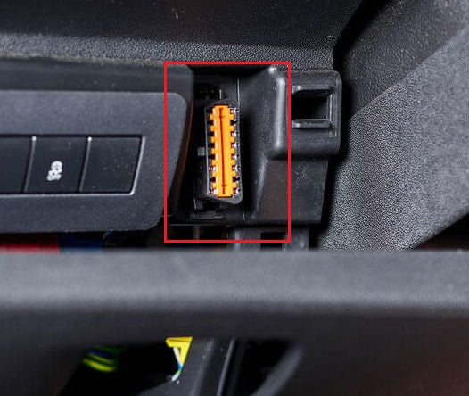Gros plan sur l emplacement d une prise OBD de couleur orange sous le tableau de bord