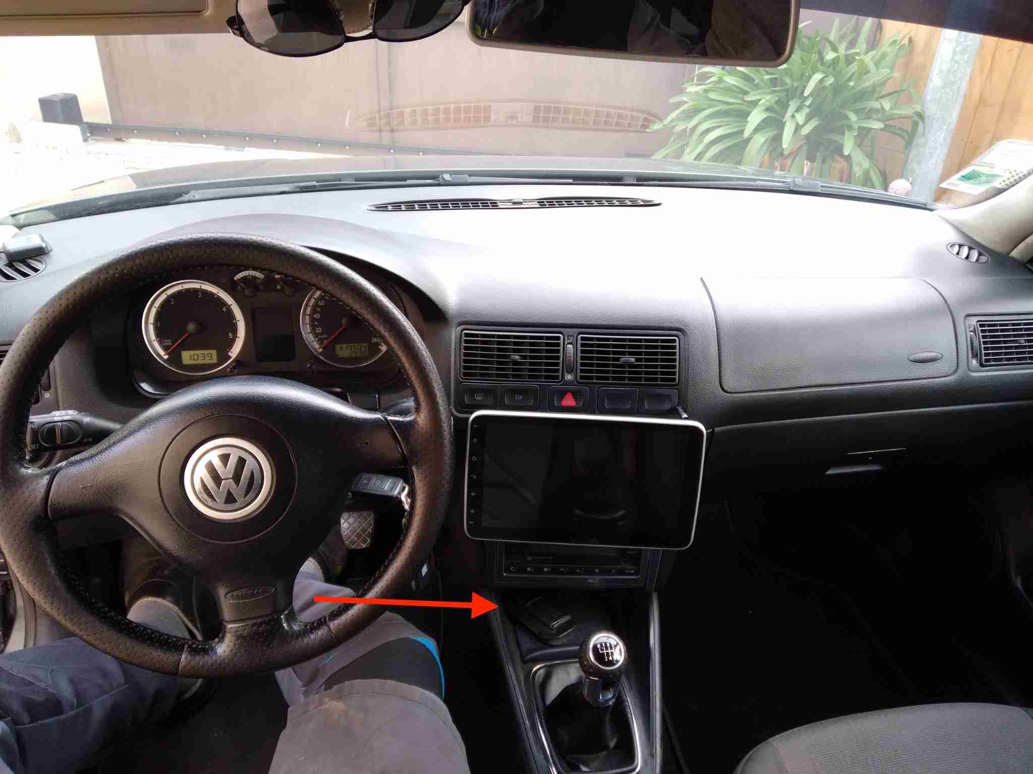 Vue de l habitacle d une Volkswagen Golf 4 avec une fleche indiquant l emplacement de la prise OBD