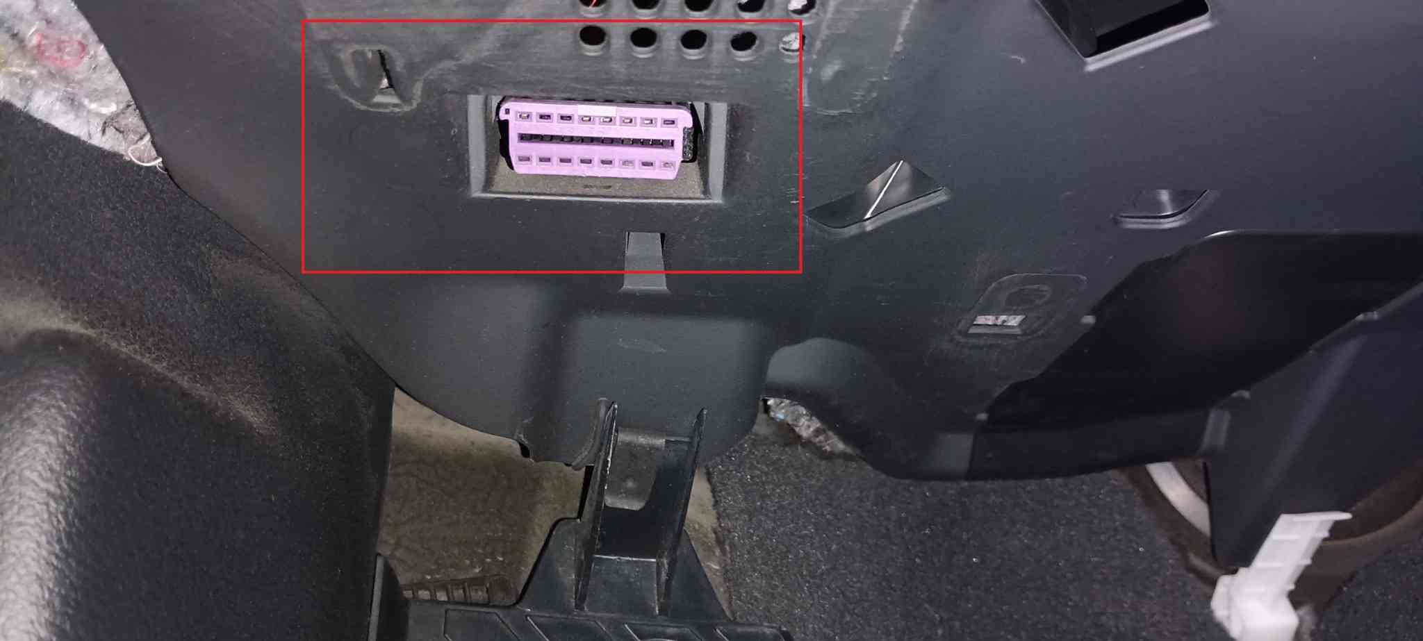 Prise de diagnostic OBD2 violette sous le tableau de bord d une Audi A6