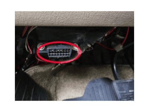 Photo de la prise OBD de diagnostic entouree en rouge sous le tableau de bord d une Chevrolet Astro 2