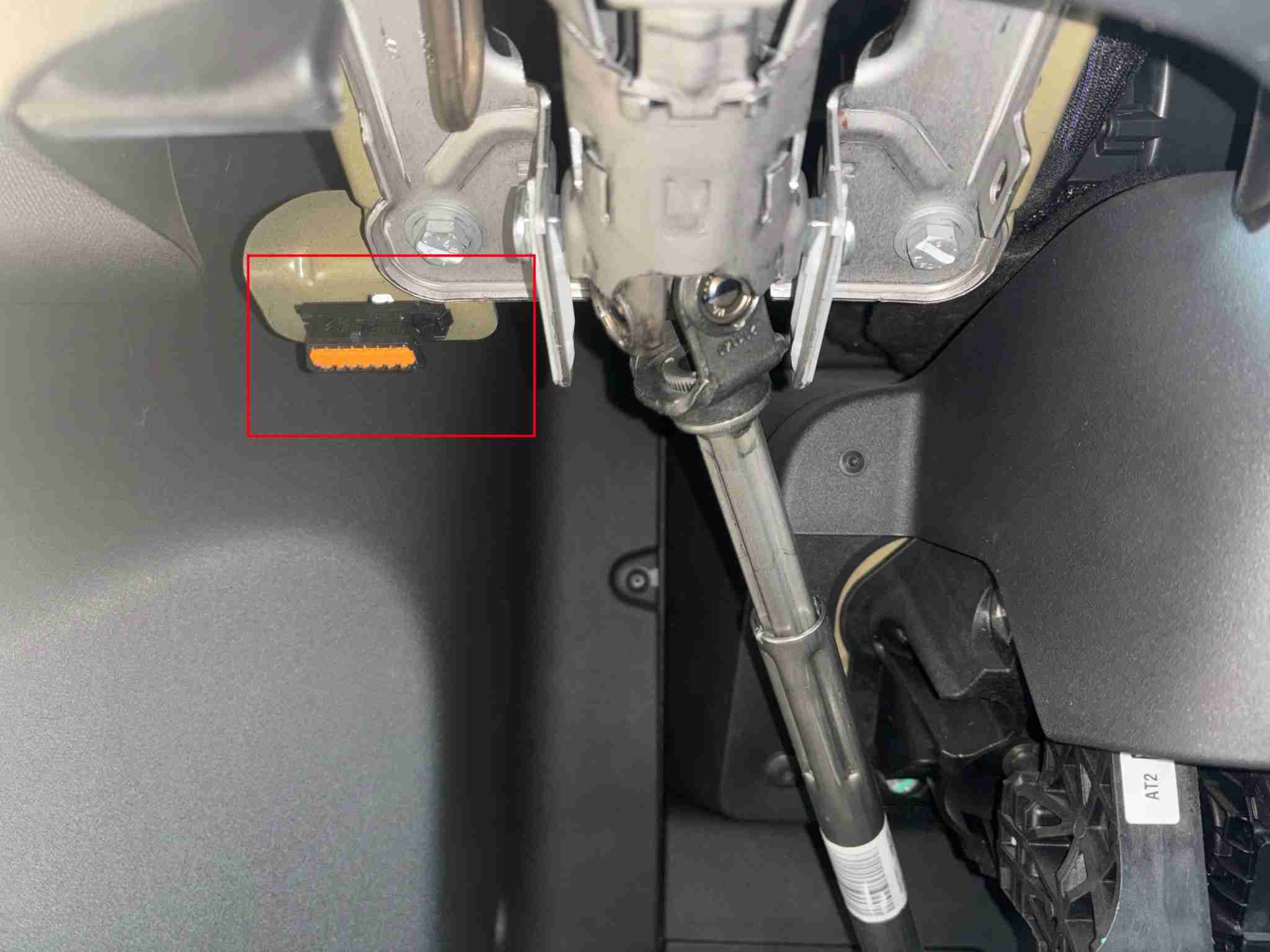 Photo montrant l'emplacement de la prise OBD2 orange sous le volant d'une Citroen Ami