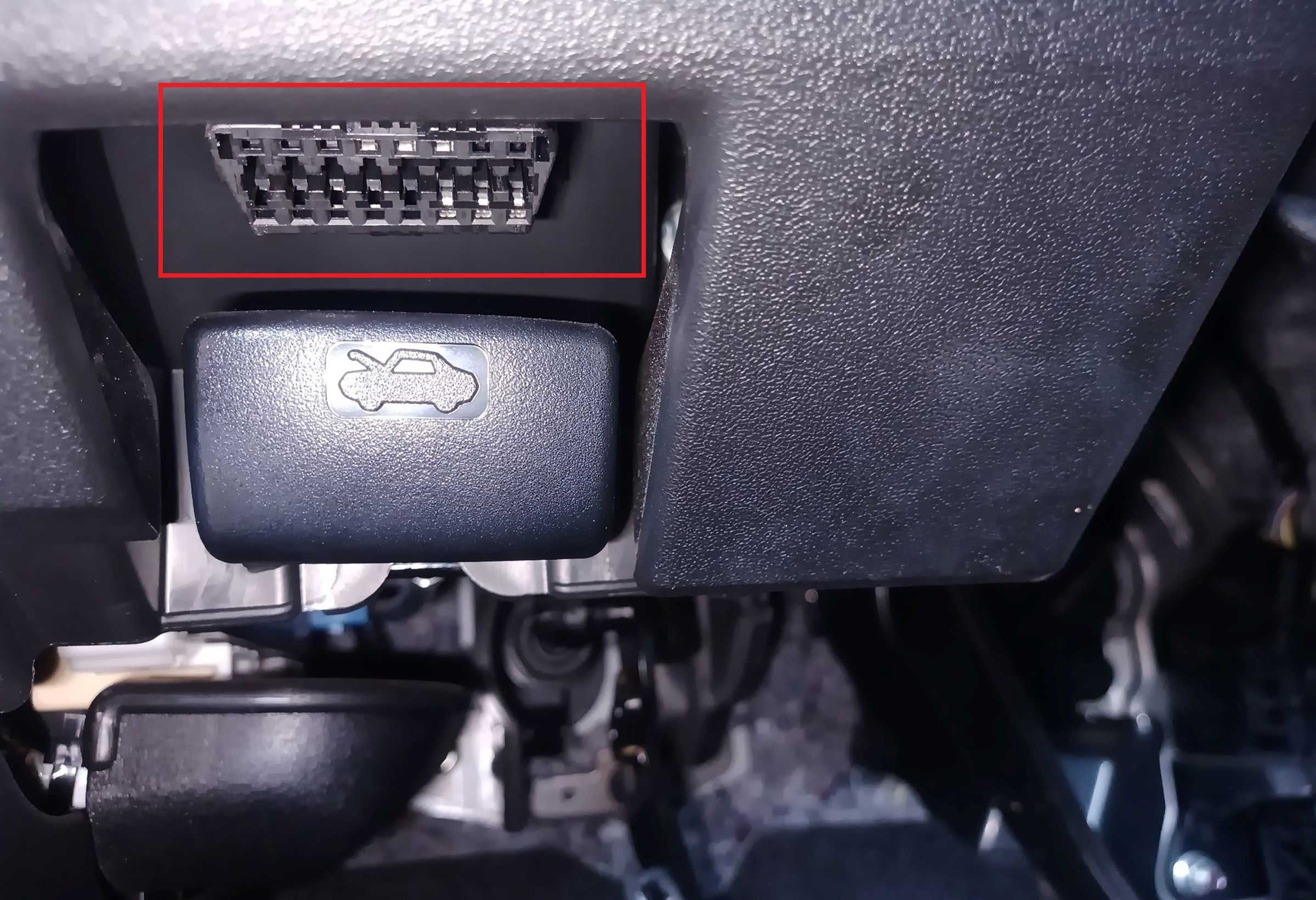 Prise diagnostic OBD2 de voiture située sous le tableau de bord au-dessus de la manette d'ouverture du capot