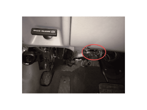 Photo de l'habitacle sous le tableau de bord d'une Ford Taurus montrant la prise OBD2