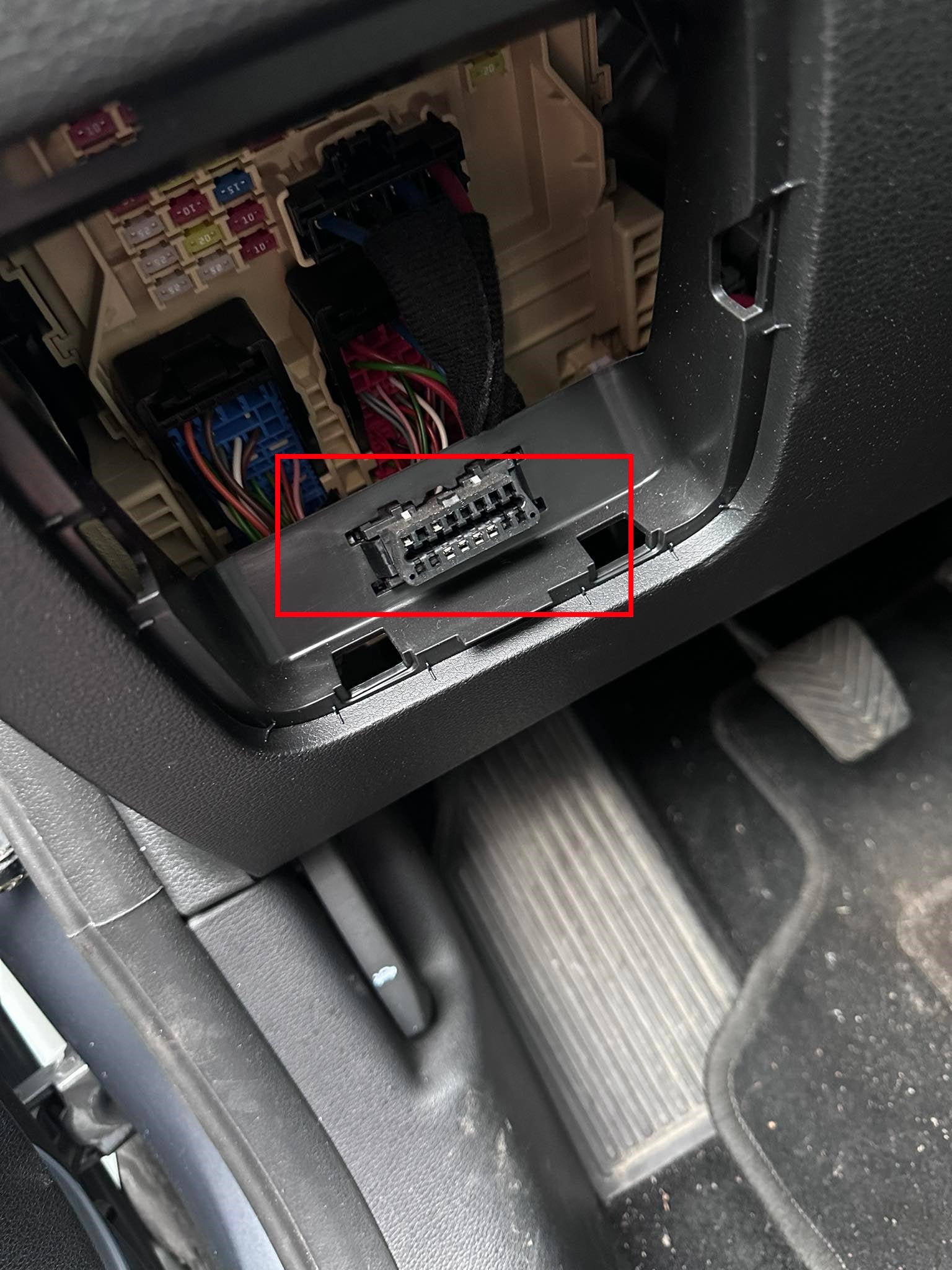 Emplacement de la prise de diagnostic OBD2 à côté de la boîte à fusibles d'un véhicule