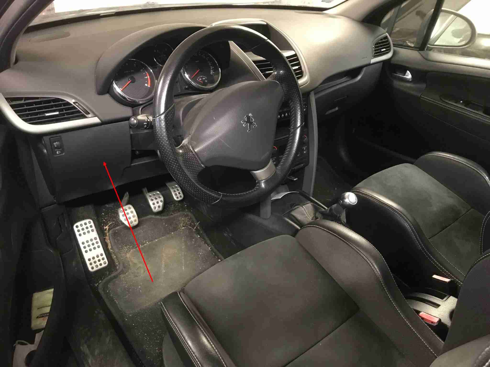 Emplacement de la prise de diagnostic OBD2 sous le volant d'une Peugeot 207