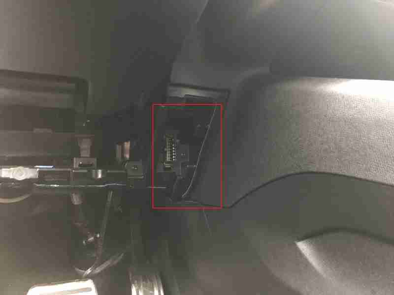 Emplacement de la prise OBD2 encadrée en rouge sur une Peugeot 5008 2 sous le volant