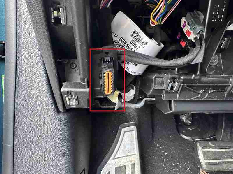 Emplacement de la prise OBD2 encadrée en rouge sous le tableau de bord d une Peugeot 308