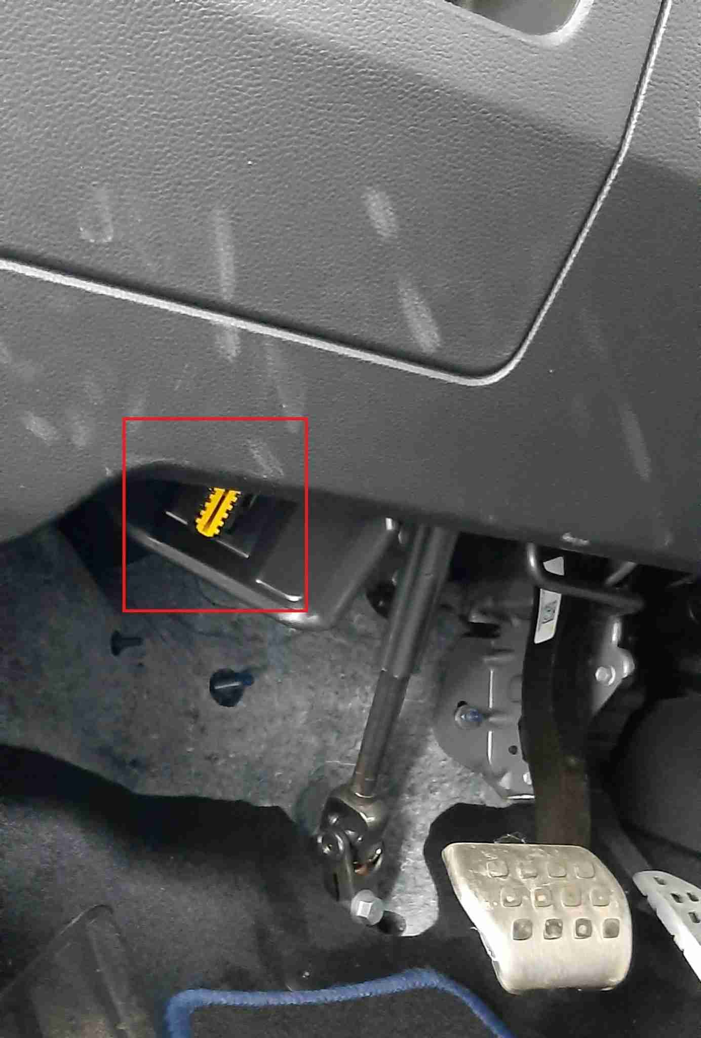 Photo montrant l emplacement de la prise OBD2 jaune sous le volant d une Renault Austral